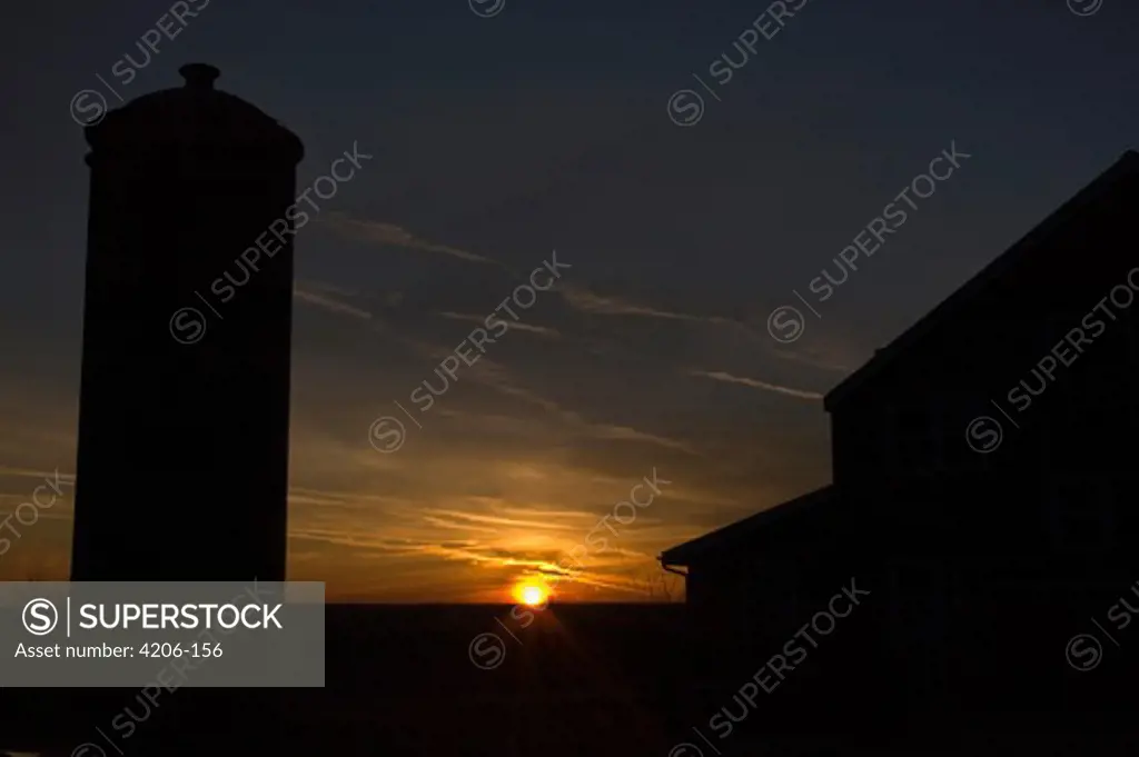 Silhouette of barn and silo at sunset, Belmont, Lafayette County, Wisconsin, USA