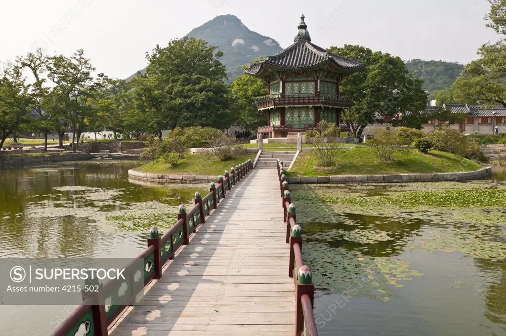 Footbridge across a pond leading towards Hyangwonjeong Pavilion, Gyeongbok Palace, Seoul, South Korea