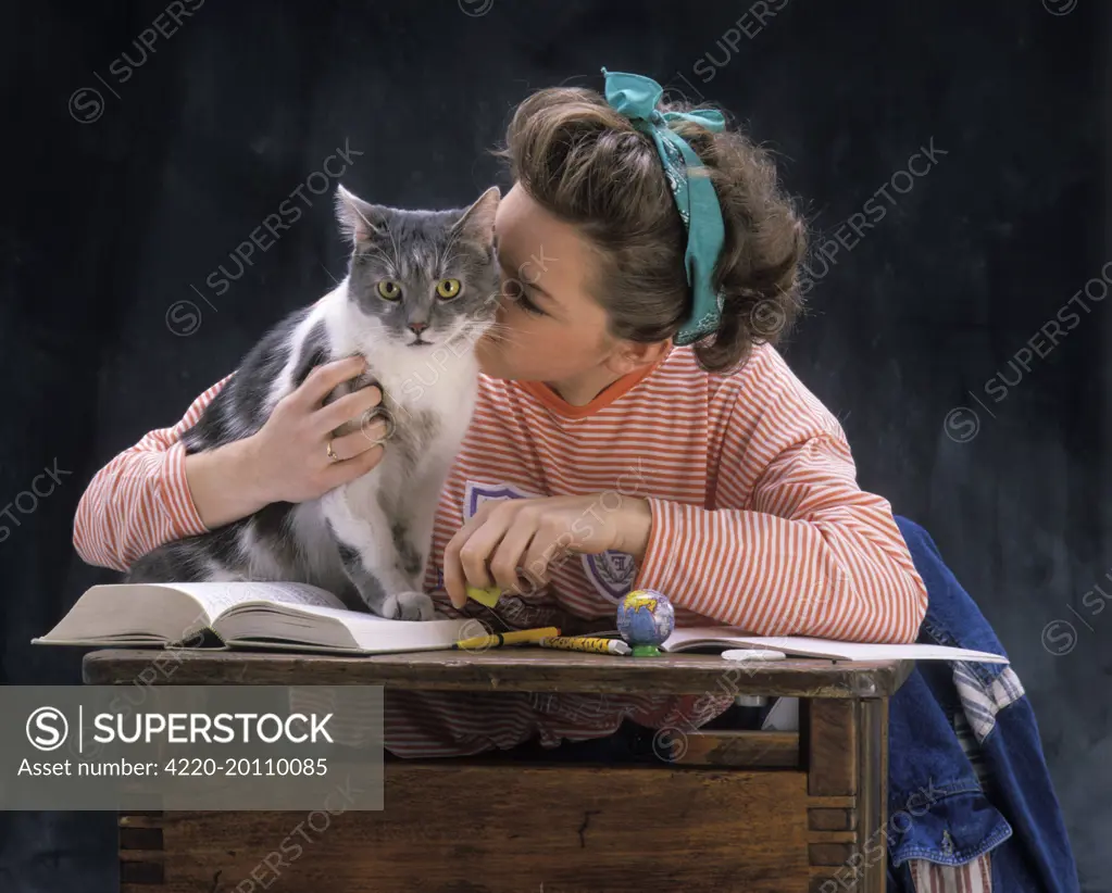 Young Girl with Cat on school desk 