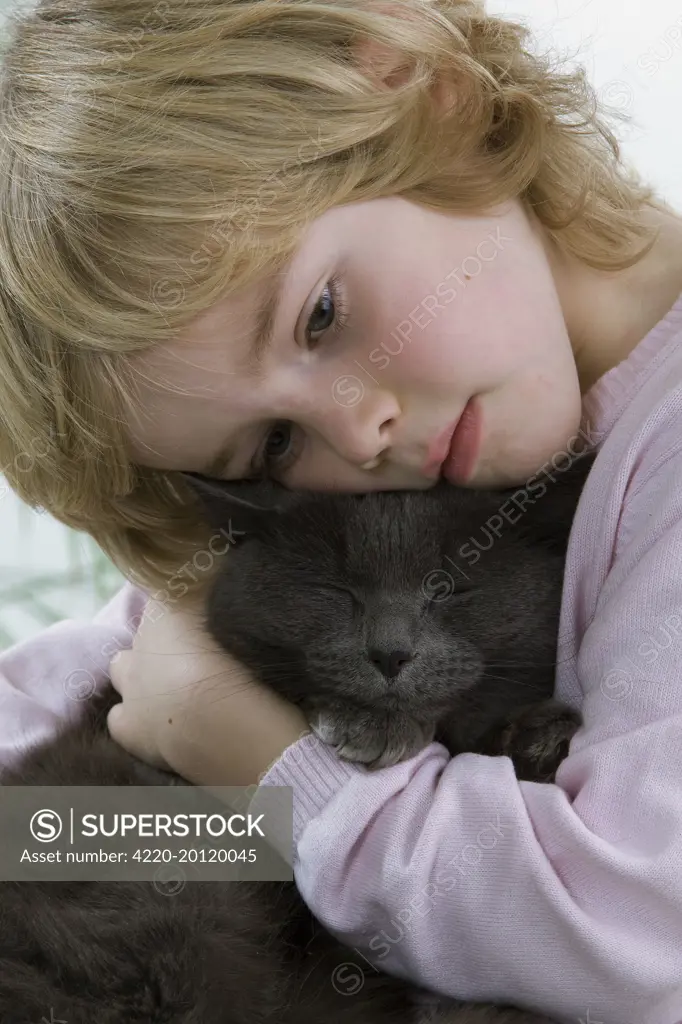 Cat - being cuddled by young child 