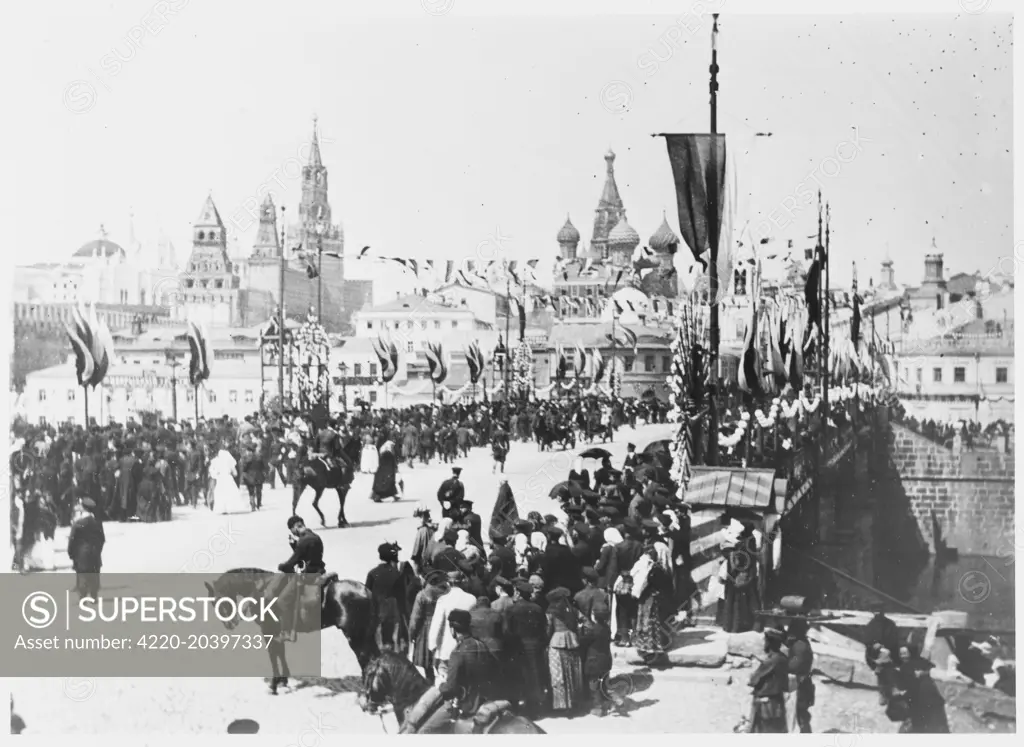 Nicolas II is crowned tsar at  St Petersburg.  The procession  crosses the Kamennyy Bridge.        Date: 26 May 1896