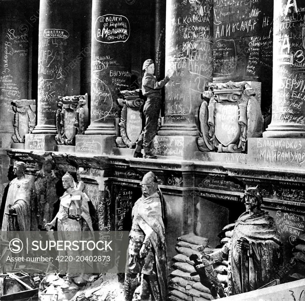 Photograph showing a British soldier adding a message to the walls of the German Reichstag, shortly after the end of the Second World War in Europe, July 1945.    Most of the graffiti visible in this picture was created by the victorious Russian soldiers after they had crushed the last Nazi resistance in Berlin.     Date: 14/07/1945