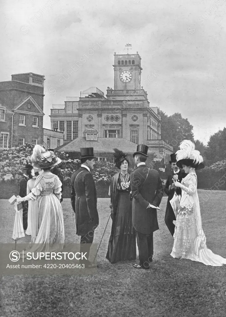 A photograph of smartly dressed society on the lawns at Ascot, 1912. The ladies are wearing large feathered hats of the period.     Date: Ascot supplement 1912