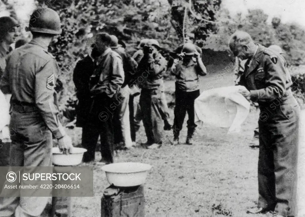 Photograph of General Dwight Eisenhower washing his hands during his visit to the Normandy Beach Head.     Date: 24th June 1944