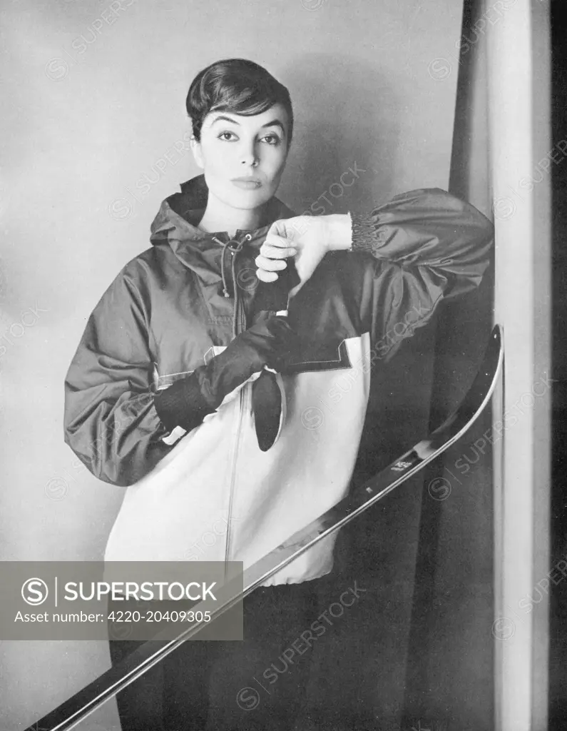 A model poses with skis in a proofed poplin jacket by Gordon Lowe from Debenhams.     Date: 1956