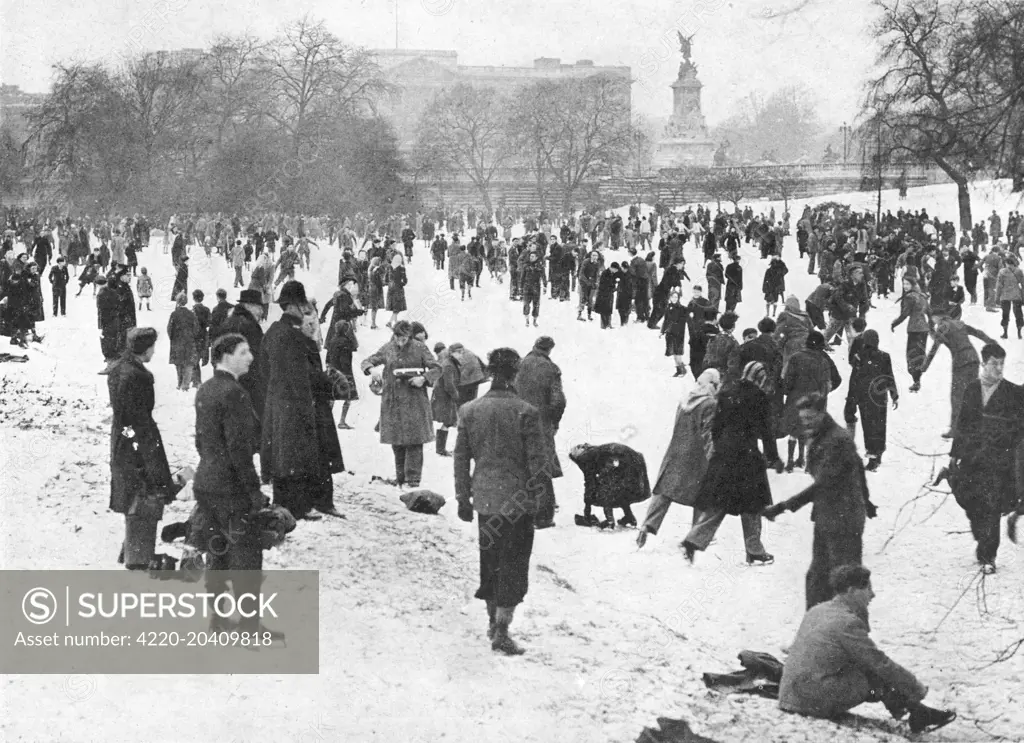 A cheerful crowd disporting on the ice in front of Buckingham Palace.  During one of the coldest winters experienced by Britain, nearly all London lakes were available for skaters, with big crowds turning out on the Serpentine, on the Round Pond, Kensington Gardens, and in Battersea Park.       Date: 1947