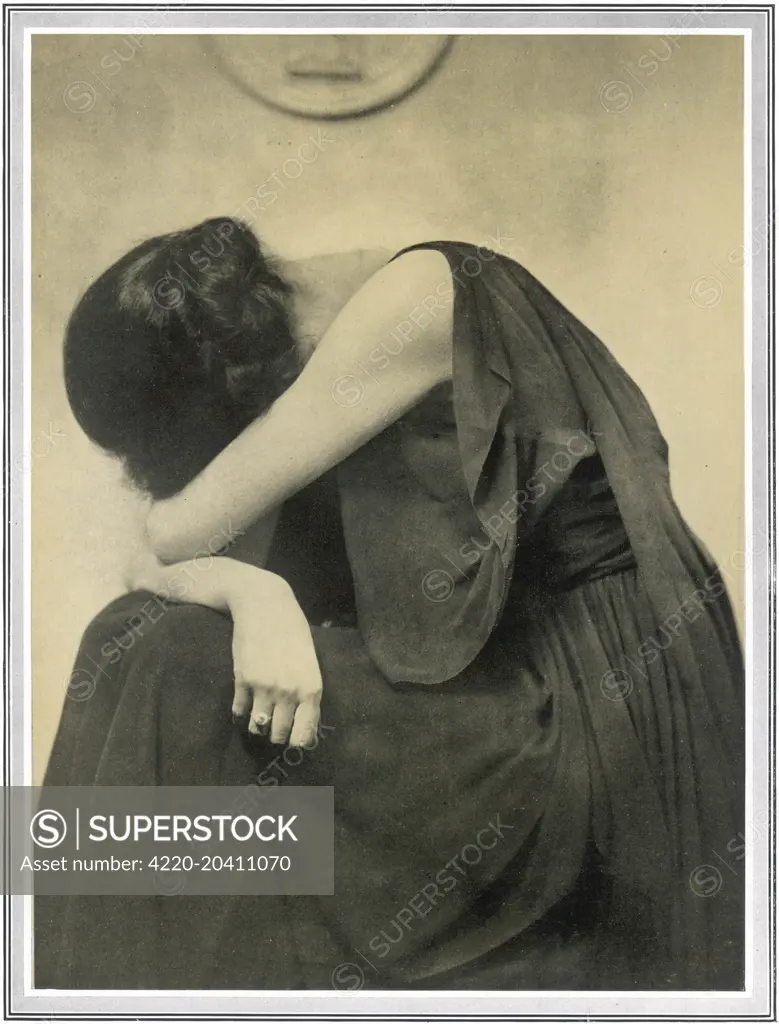 A woman holds her head in her arms in this camera study by Hugh Cecil depicting 'grief'.       Date: 1919