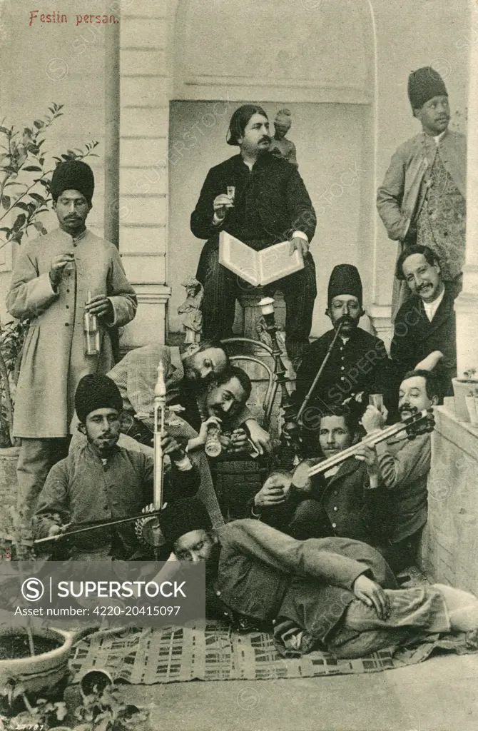 A group of Iranian men (in a variety of states of sobriety!) following a 'Festan Persan' or 'Royal Persian Feast' in Tehran, Iran. A number of the men are holding and playing musical instruments, a hubble bubble (houkah) pipe is being enjoyed and alcohol is being consumed left right and centre!     Date: 1913