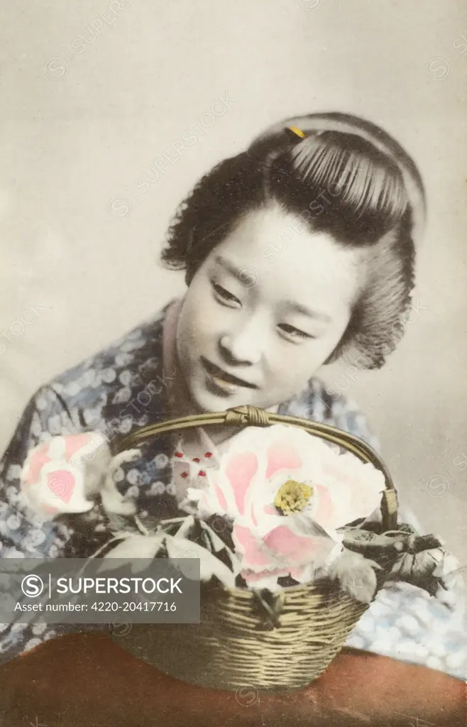 Young geisha girl with a basket of flowers.     Date: circa 1910s