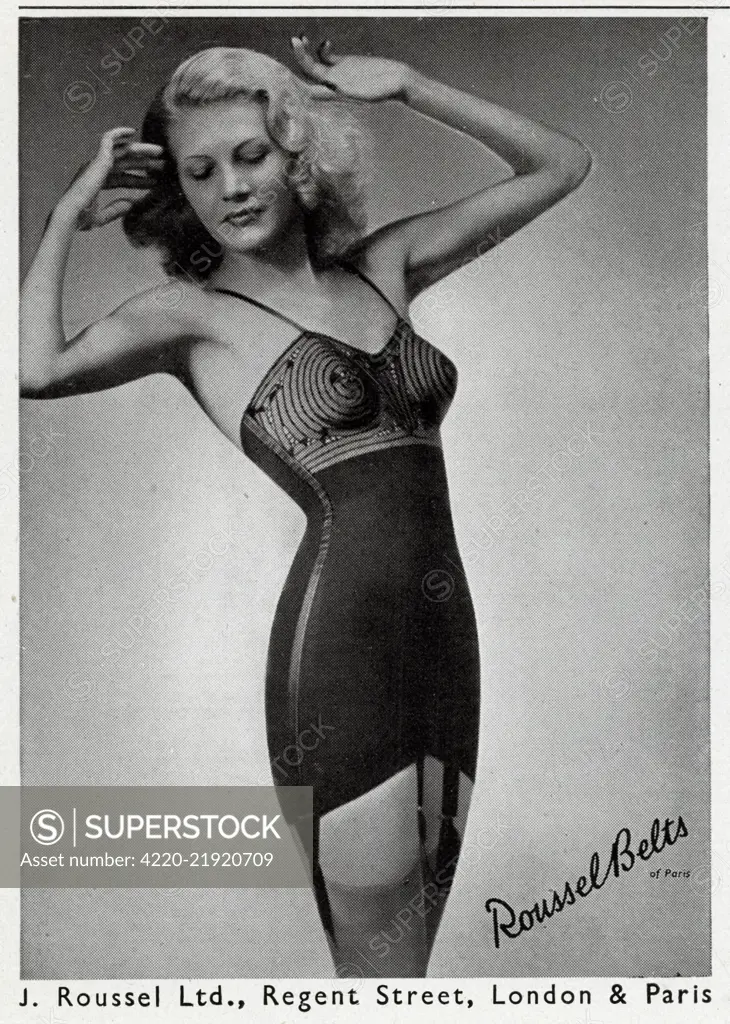 A blonde bombshell model wearing the Roussel suspender belt garment, with  bullet padding bra. Date: 1948 - SuperStock