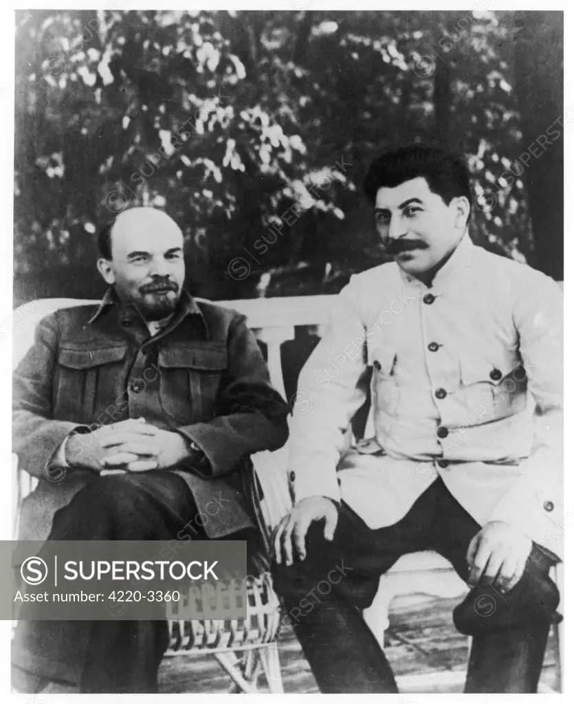 Vladimir Ilyich Lenin (1870 - 1924) and Josef Stalin (1879 - 1953), Communist Russian leaders, sitting on a bench.       Date: circa 1920