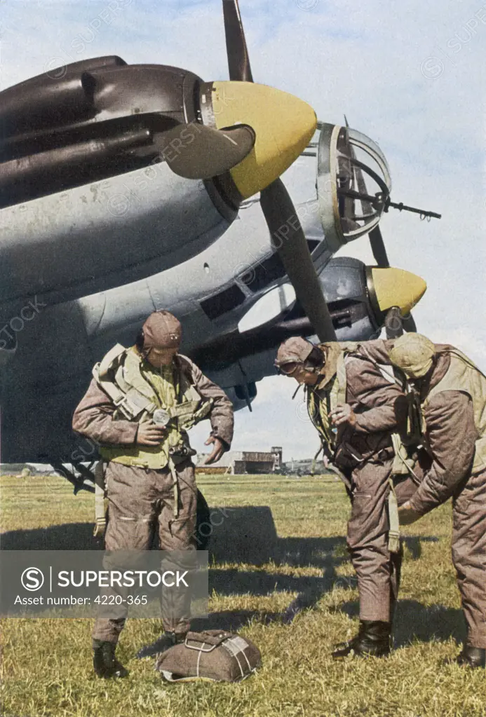 German aircrew prepare for a  mission (putting on  parachutes). Aircraft is  probably a Heinkel HE-111       Date: 1940
