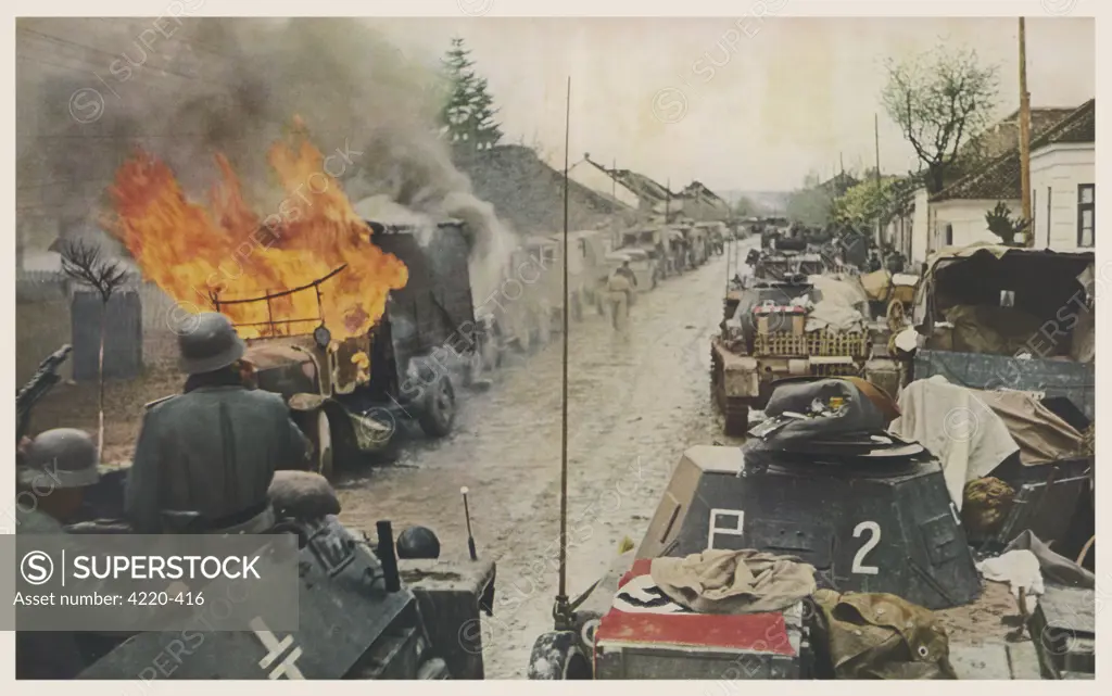 Serbia : A German armoured car  moves forward down a village  street, lined on the left by  burning or captured Serbian  vehicles, on the right by  victorious German tanks     Date: June 1941