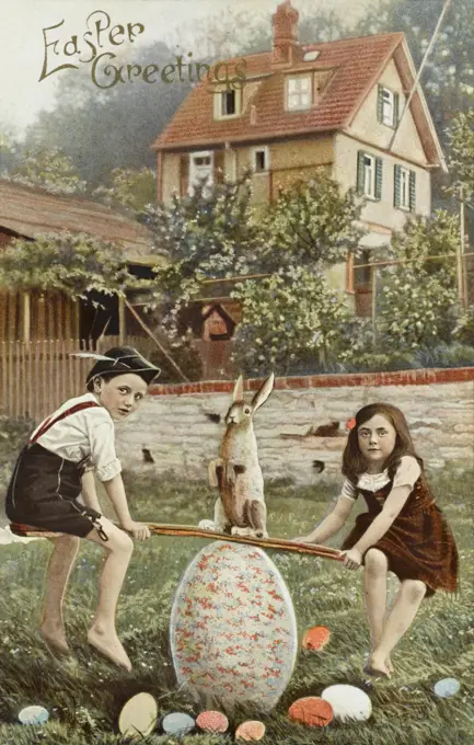A rather splendid symbolism-packed Easter card, with two children, a boy and a girl, playing on a see-saw balanced on a giant Easter egg. The Easter bunny is sitting at the fulcrum and colourful (yet smaller) Easter eggs surround them.     Date: 1909