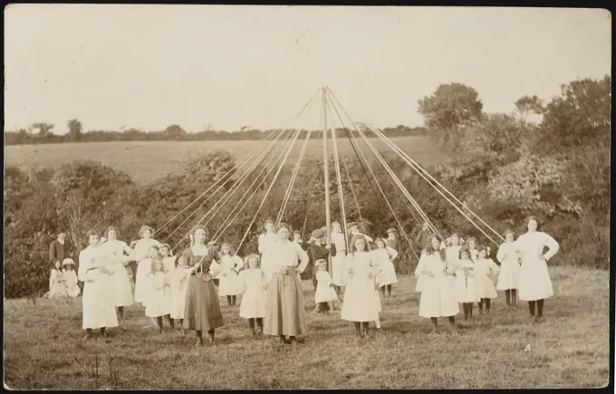 Children pose for the camera  before starting their dance in  an open field        Date: circa 1905