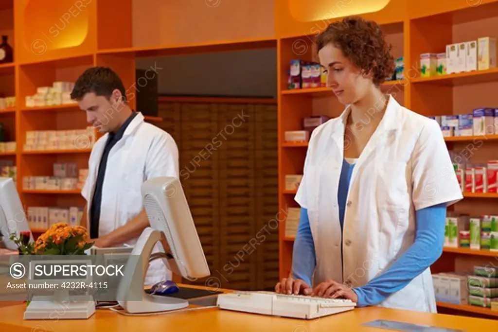 Pharmacist and PTA in pharmacy working behind desk