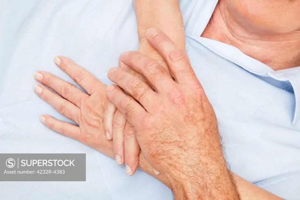 Two pair of senior hands touching each other gently