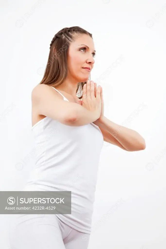 Elderly woman in white praying with her hands folded