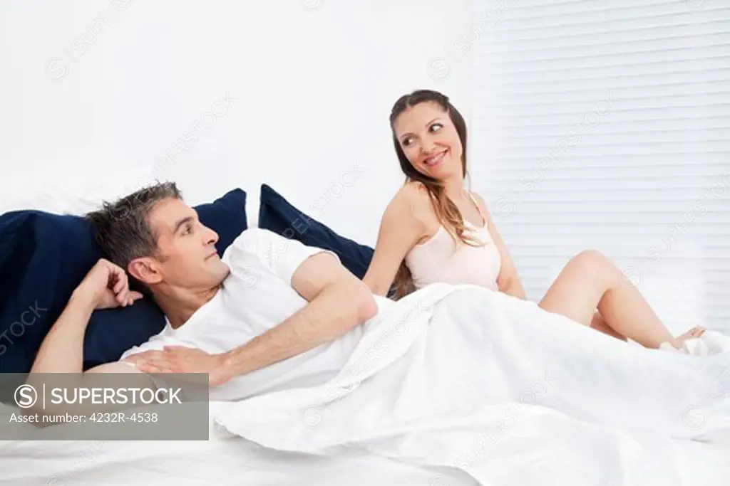 Happy smiling senior couple laying in bed