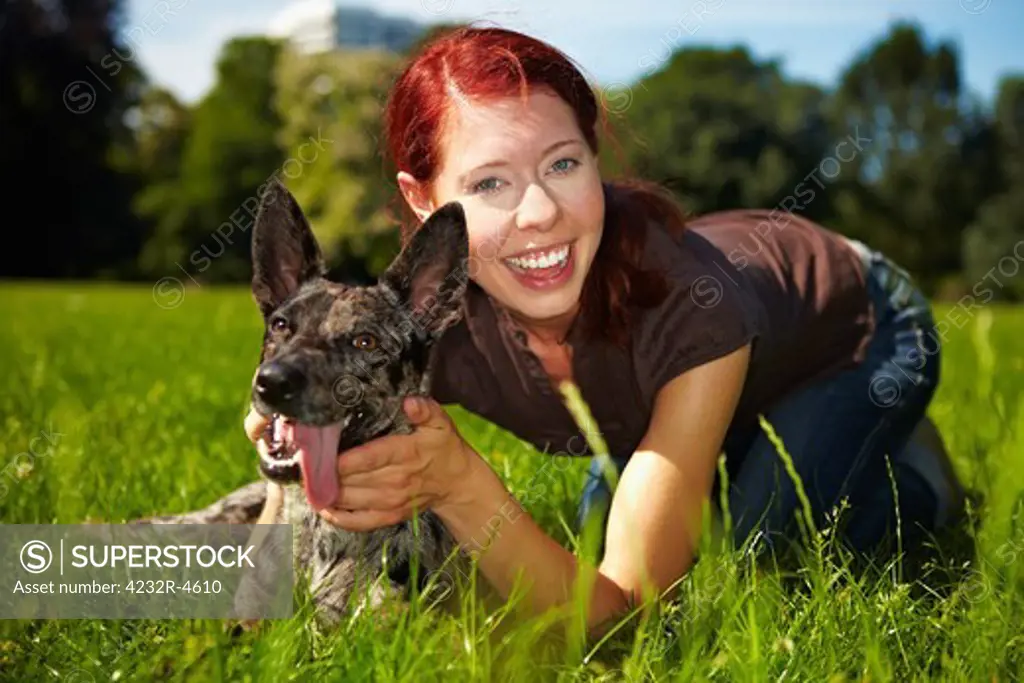 Portrait of smiling woman with happy dog in park