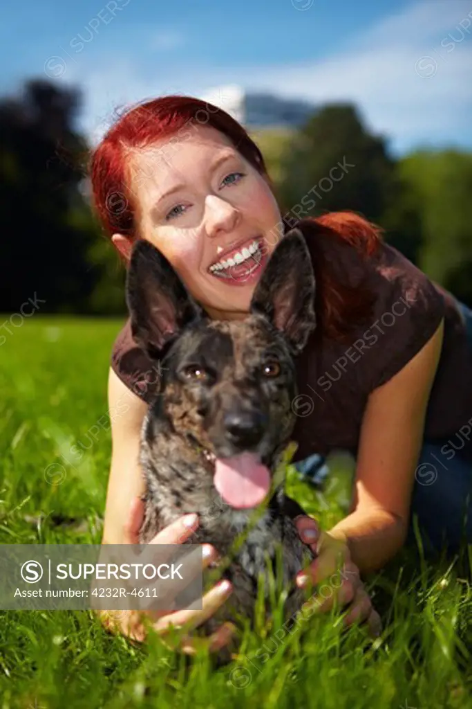 Happy woman holds her dog in a park