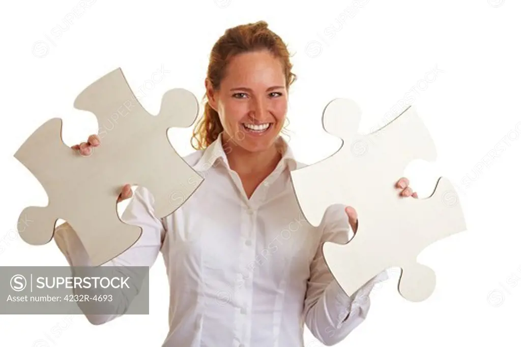 Happy business woman with two oversized jigsaw pieces