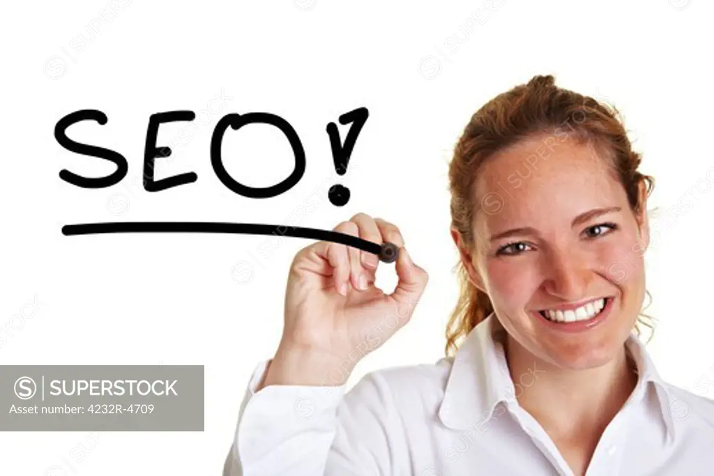 Smiling business woman writing the word SEO with pen