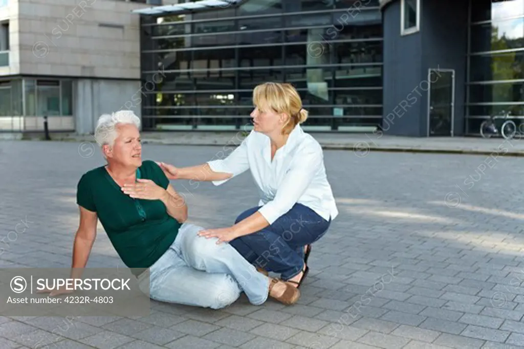 Passerby helping weak senior woman with stroke