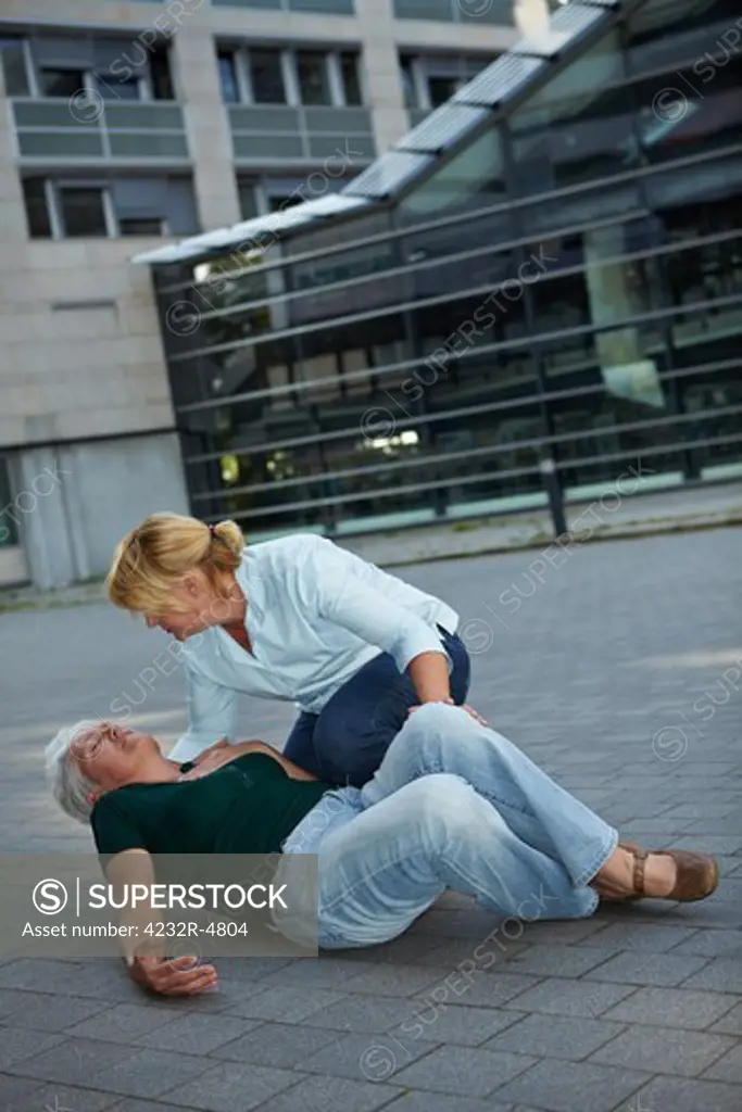 Passerby helping a senior woman with seizure
