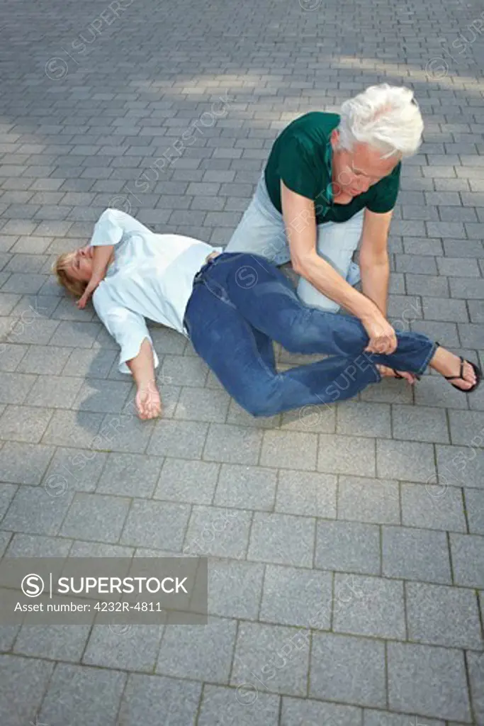Senior woman using recovery position on unconscious woman