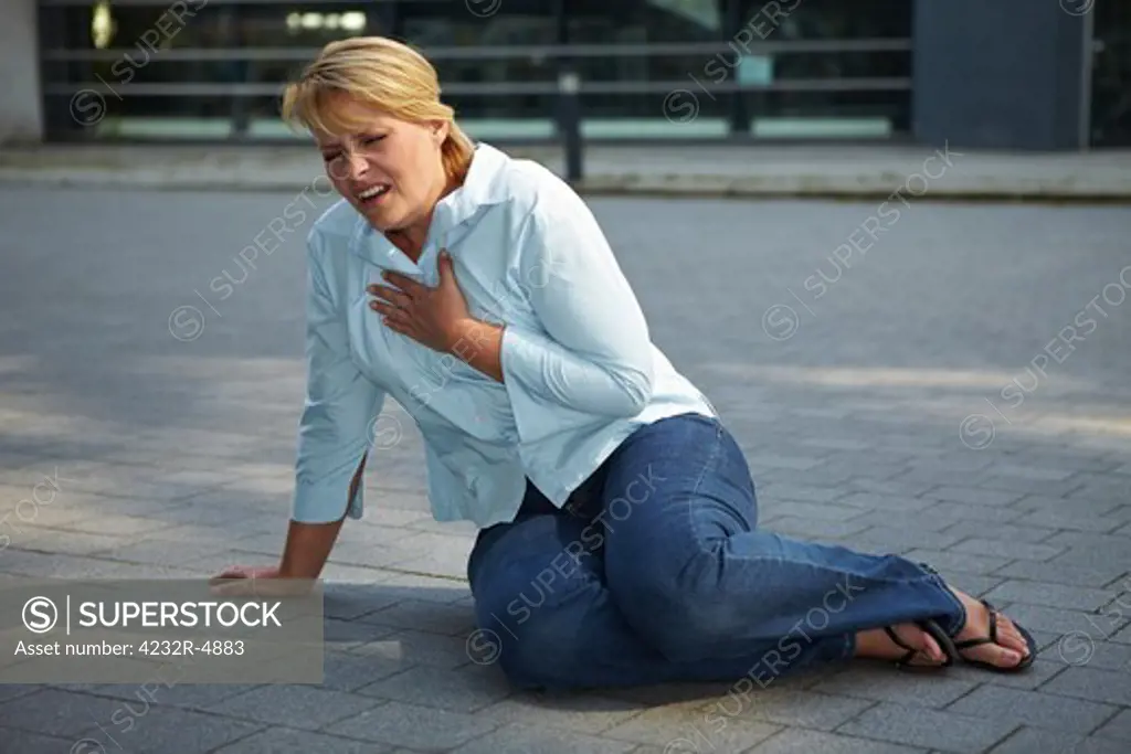 Breathless woman sitting exhausted on a sidewalk