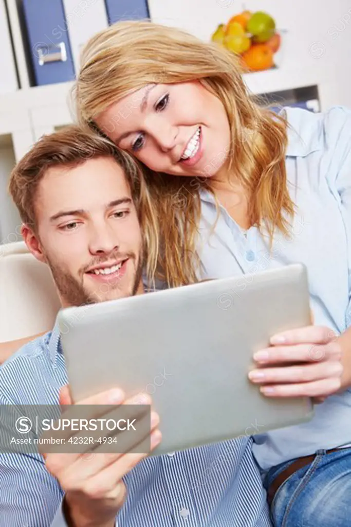 Happy couple watching movie as online stream on a tablet computer