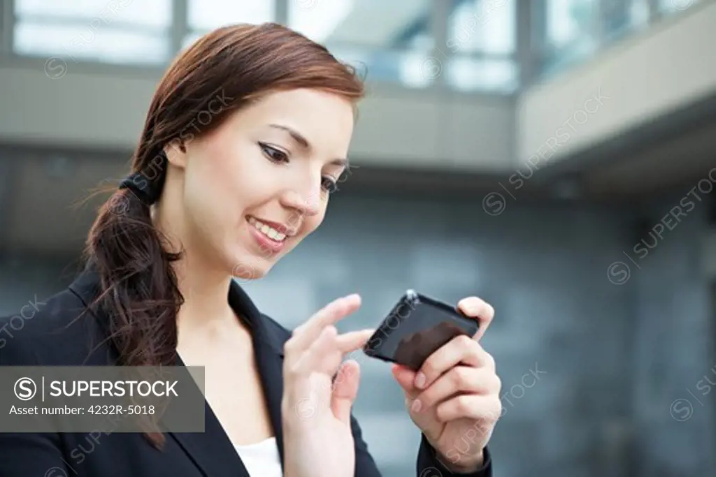 Attractive young woman using her smartphone on the way in the city
