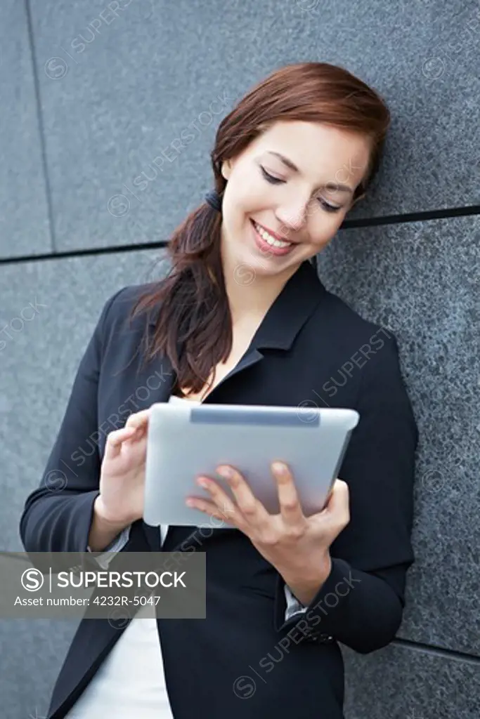 Mobile business woman working with tablet PC in the city