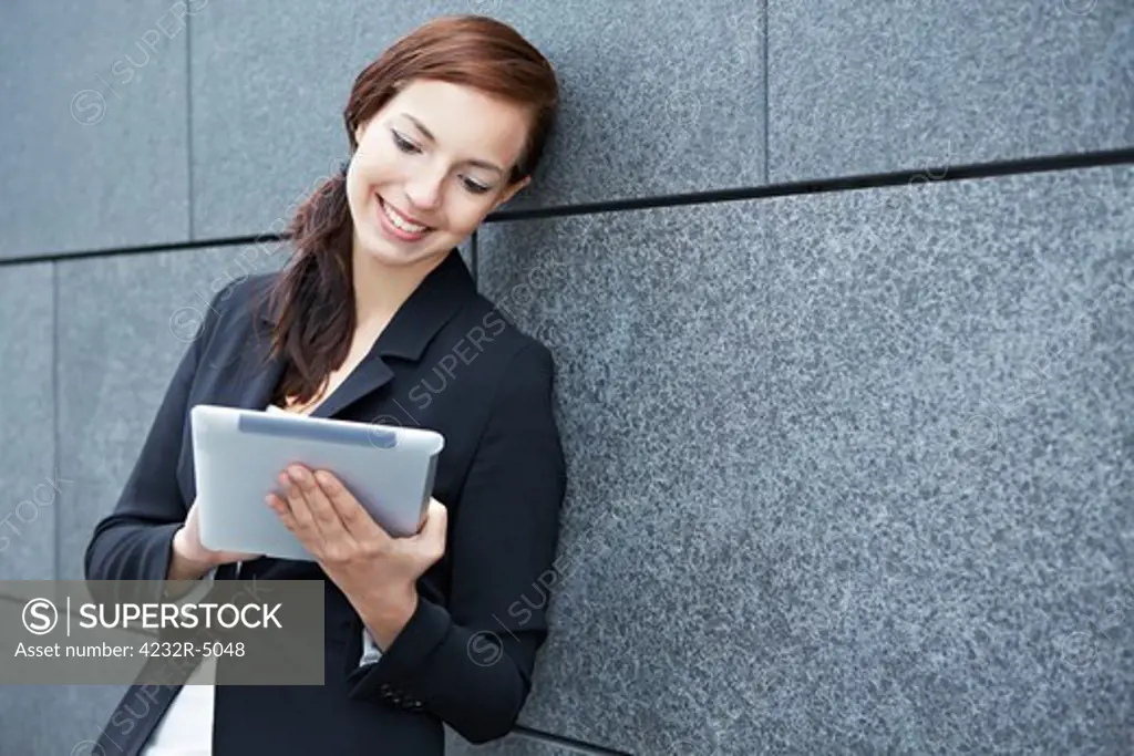 Business woman working on the way with tablet computer