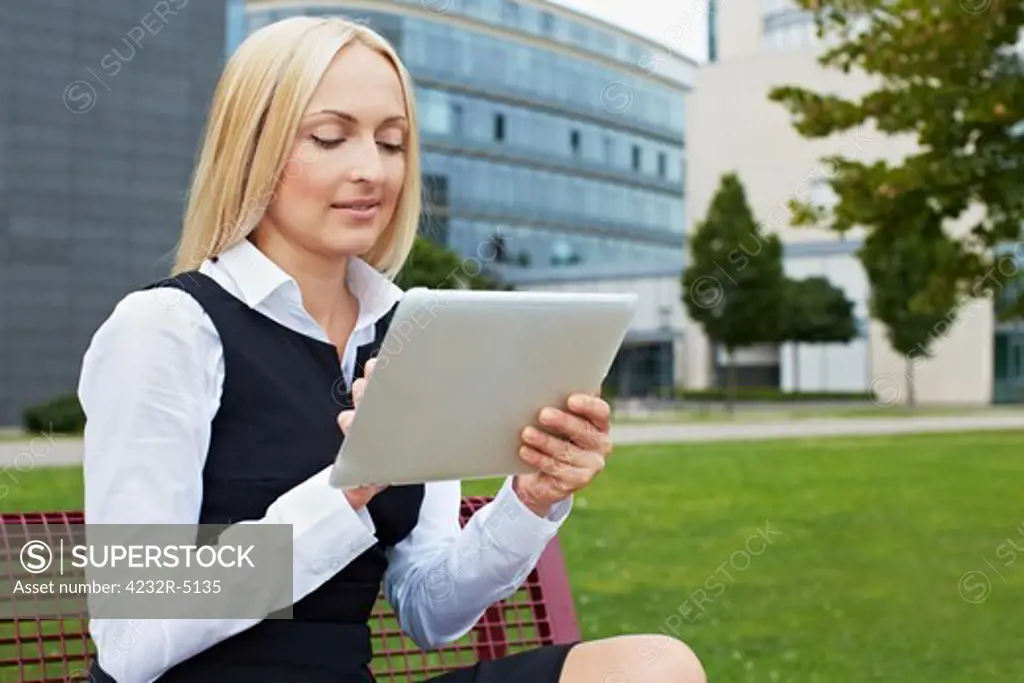 Attractive business woman outside holding a tablet PC