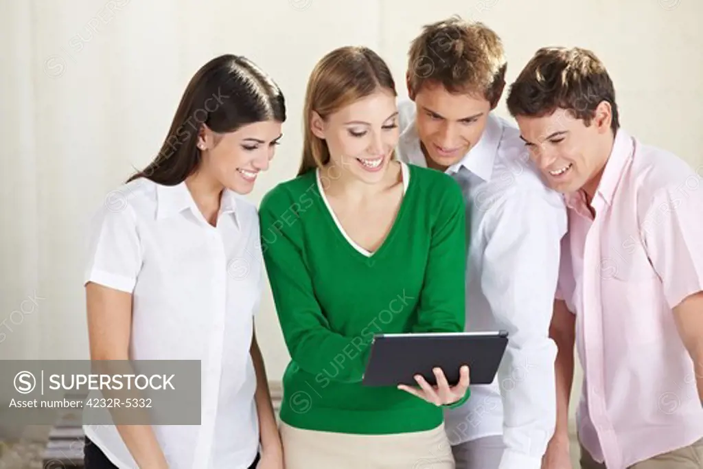 Group of happy students looking at a tablet computer