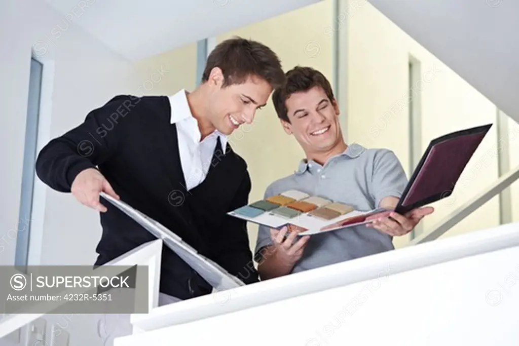 Sales representative showing craftsman in office a sample folder
