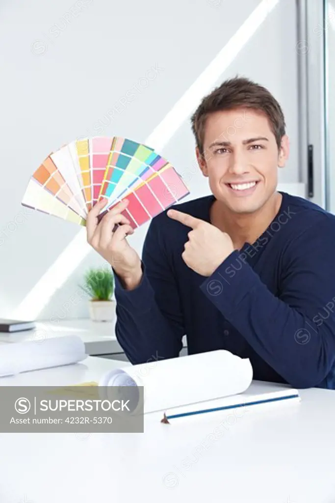 Happy graphic artist in his office showing color fan
