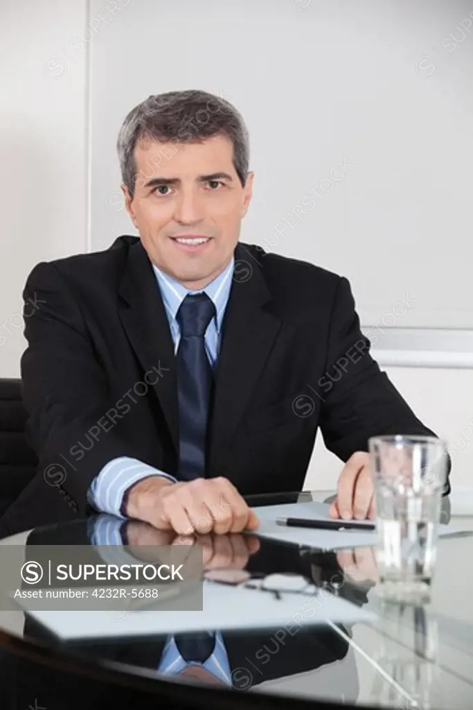 Elderly entrepreneur sitting at his desk in his office