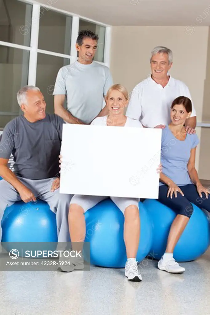 Senior citizens on gym balls doing advertising for fitness center