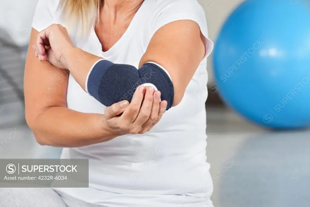 Woman with joint pain and bandage in gym