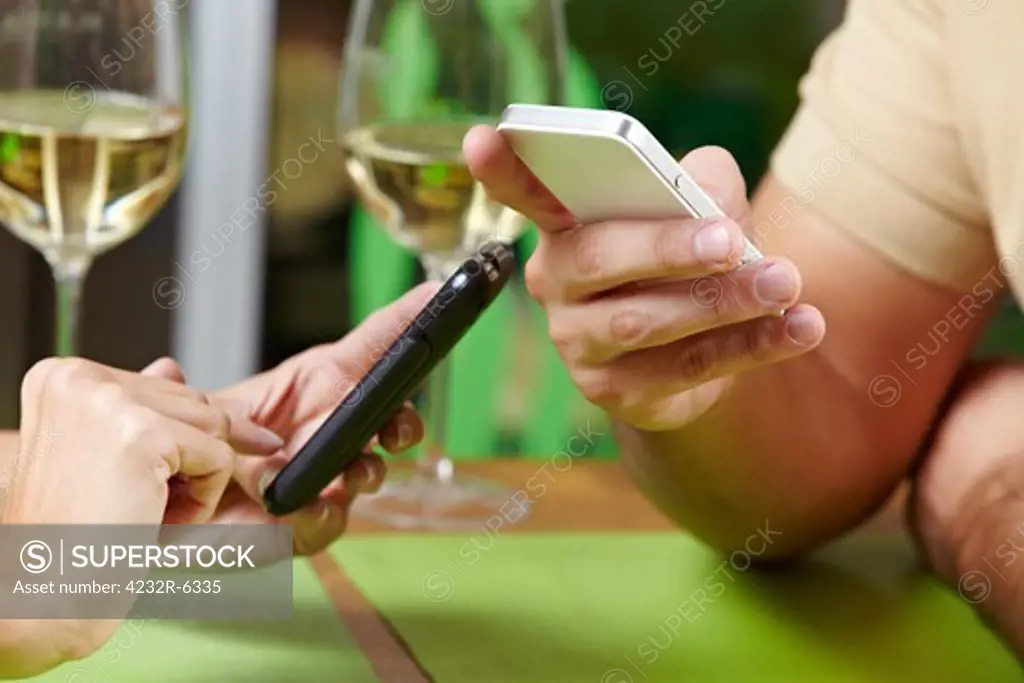 Couple using their smartphones at the same time in a restaurant
