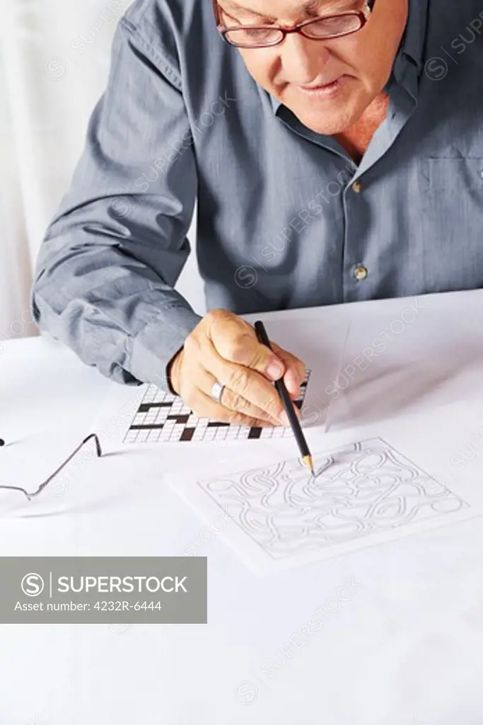 Senior with reading glasses solving a riddle in a rest home
