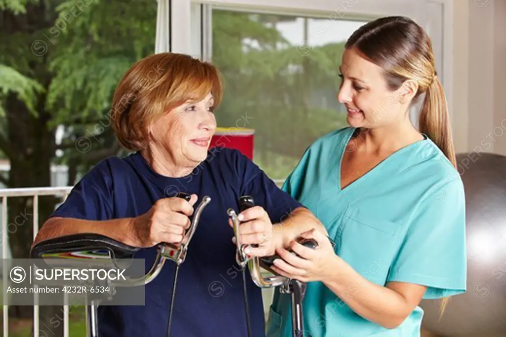 Nurse helping senior woman in rehab in a physiotherapy