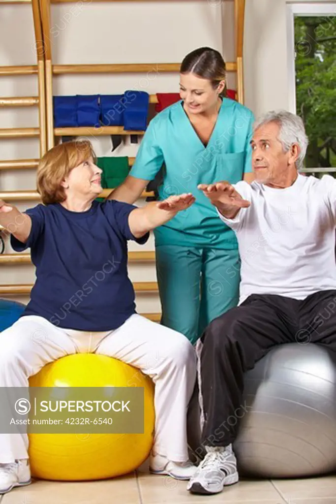 Two senior people doing back fitness training with physiotherapist