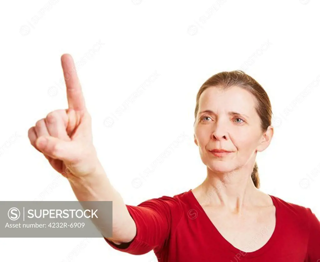 Senior woman holding index finger up and pressing invisible touchscreen