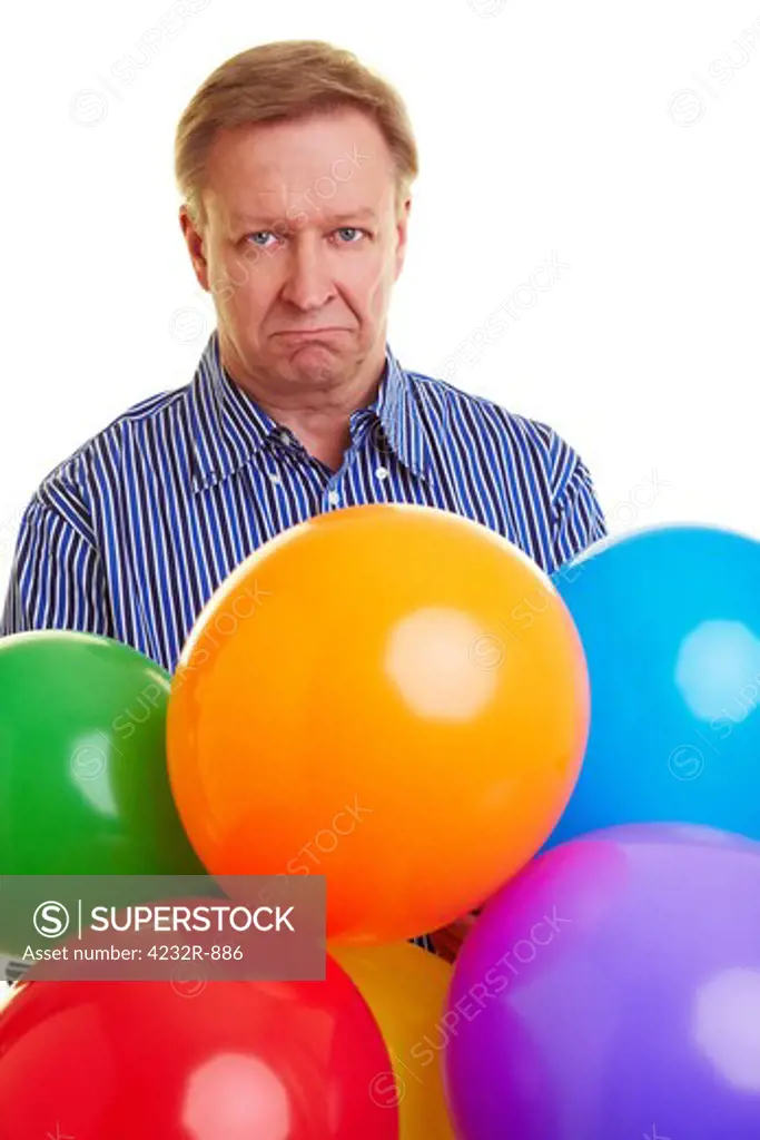 Sad elderly man holding many colorful balloons