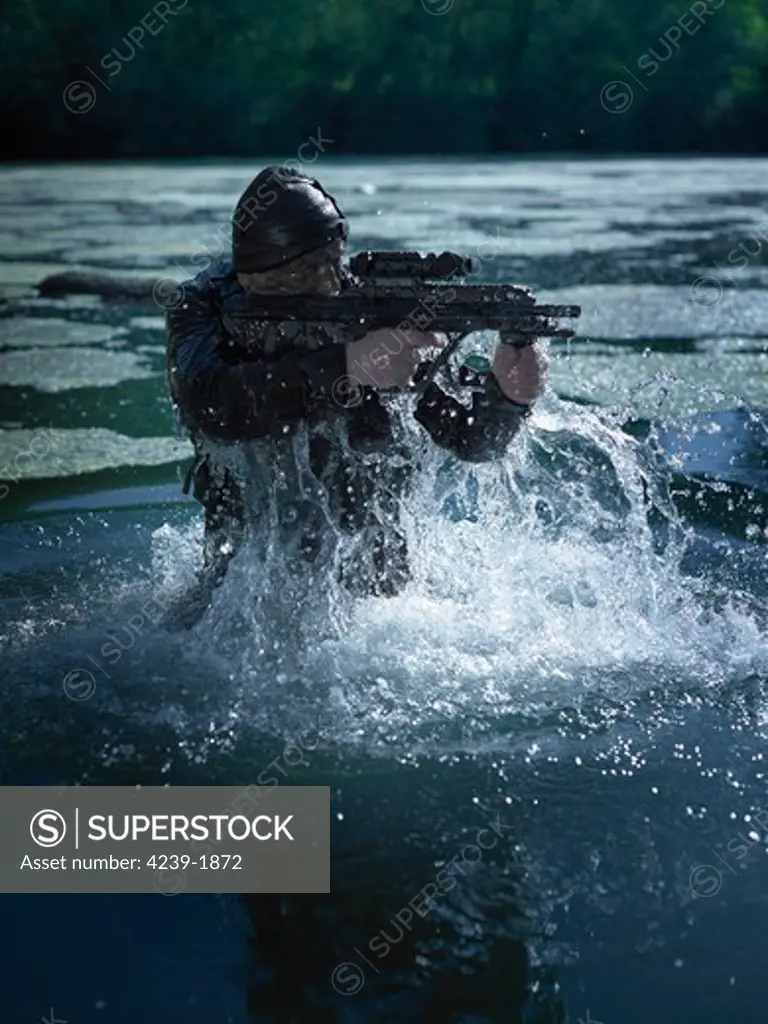 Special operations forces soldier emerges from water armed with a Steyr AUG assault rifle.