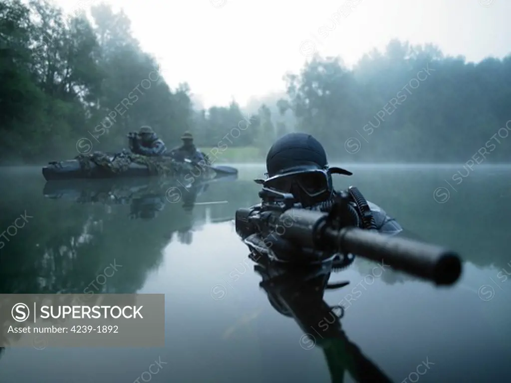 Special operations forces combat diver transits the water armed with an assault rifle.
